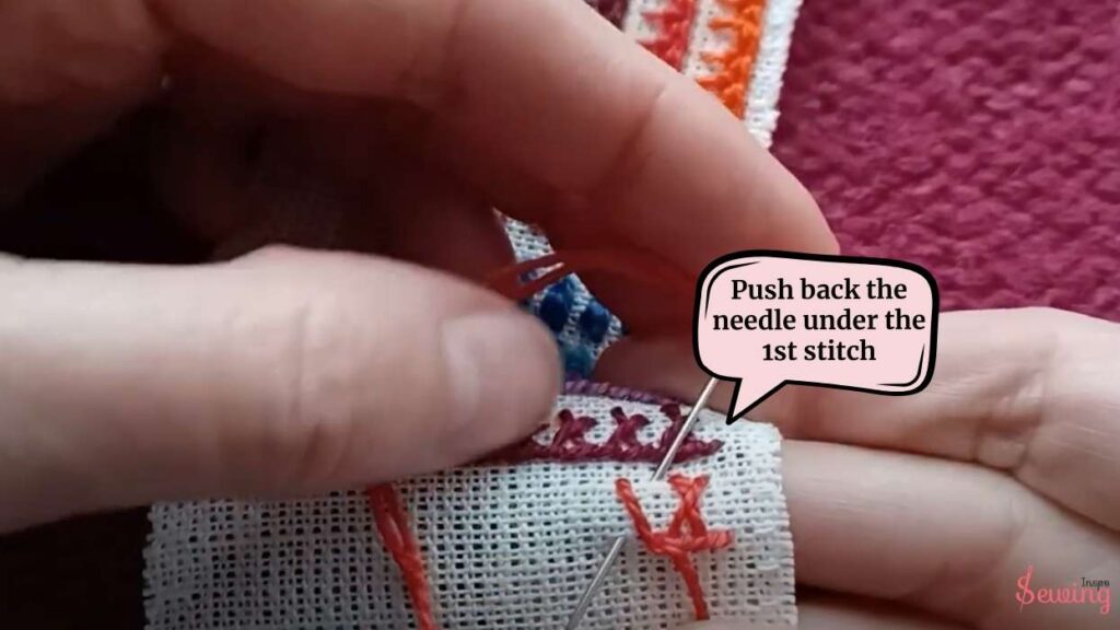 Push back the needle under the 1st stitch