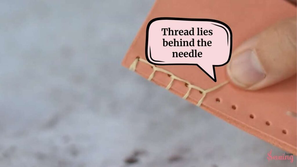 Thread lies behind the needle