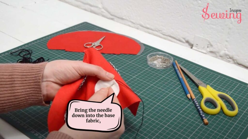 Bring the needle down into the base fabric