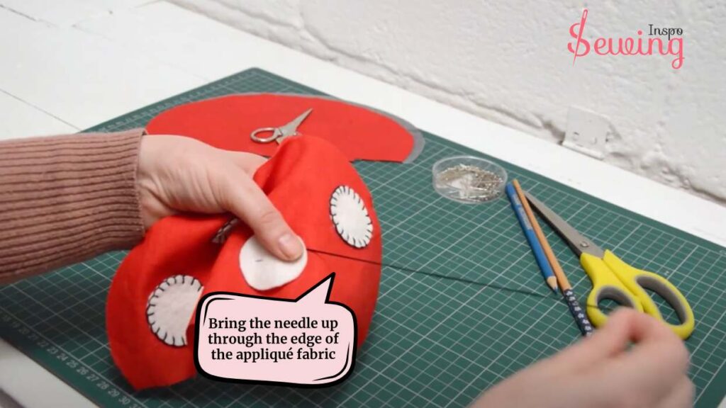 bring the needle up through the edge of the appliqué fabric