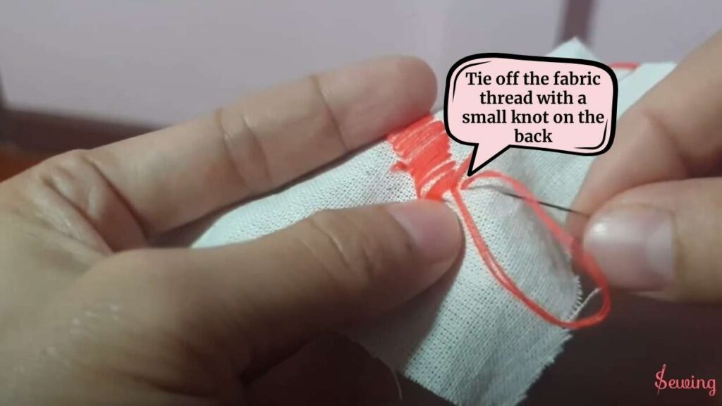 Tie off the fabric thread with a small knot on the back