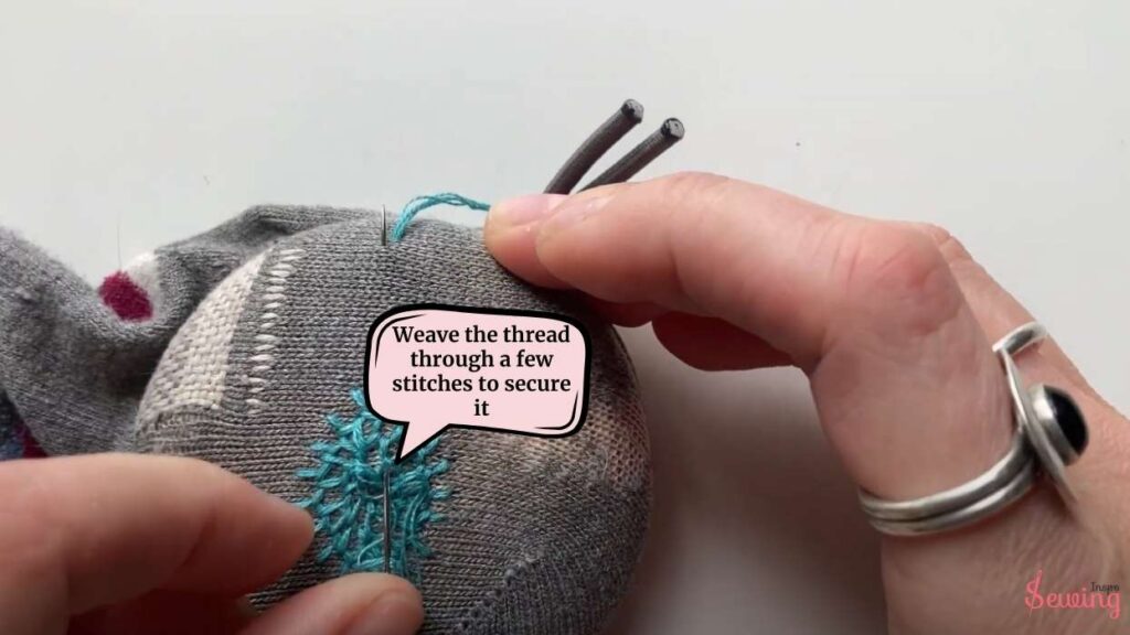 weave the thread through a few stitches to secure it