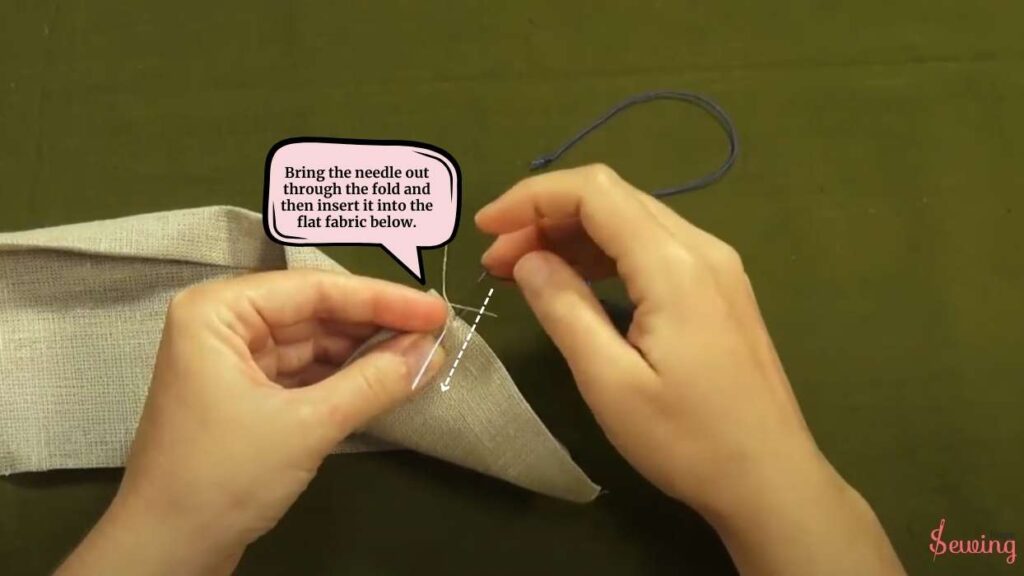 Bring the needle out through the fold and then insert it into the flat fabric below